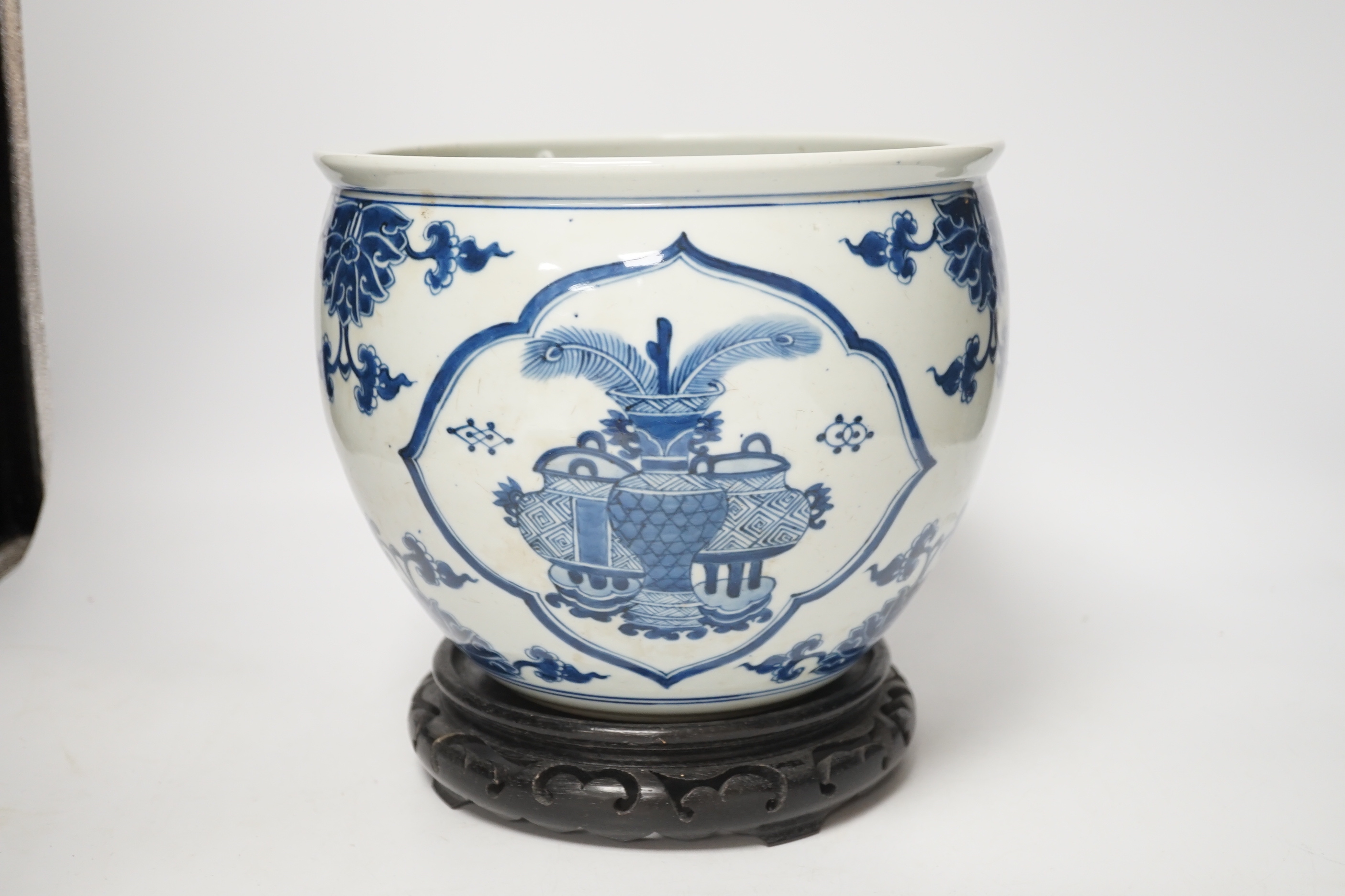 A Chinese blue and white jardiniere and hardwood stand, total height 23cm